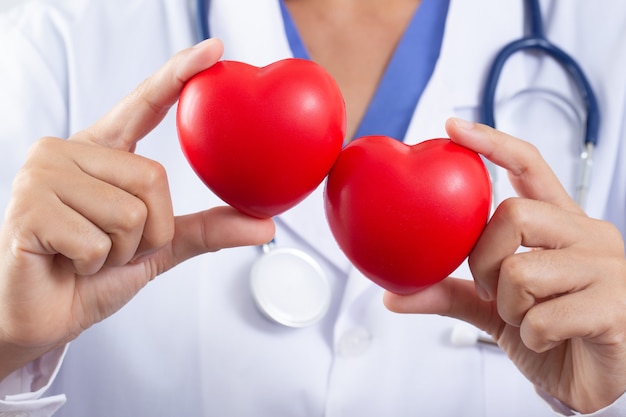 Medico che tiene il concetto di cuore sul trattamento delle malattie cardiache
