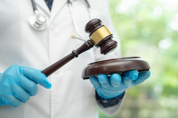 Doctor holding judge gavel forensic medicine medical law and crime justice concept