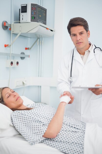 Doctor holding medical results and the hand of his patient