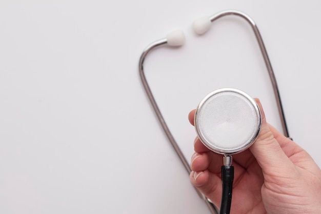 Doctor holding a medical stethoscope on a plain background