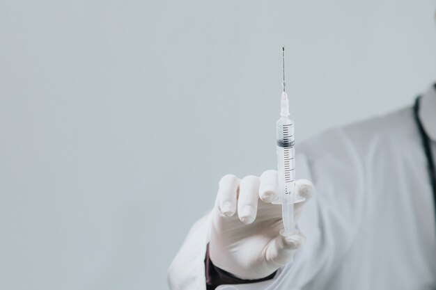 Doctor holding medical syringe