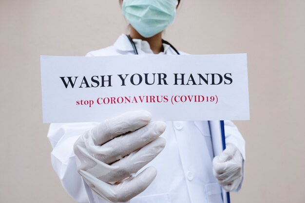 Foto dottore che tiene il messaggio, lavarsi le mani, fermare il coronavirus, covid-19.