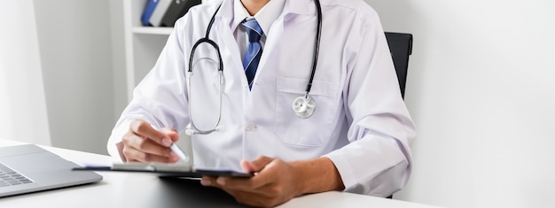 Doctor holding the patient report file to assess symptoms on the desk.