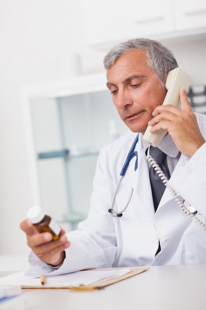 Photo doctor holding a phone and drug box