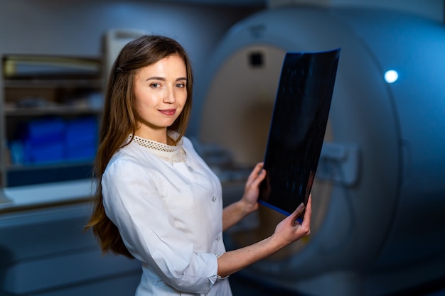 Medico in possesso di un'immagine di un flusso di lavoro di risonanza magnetica cerebrale in ospedale diagnostico. sanità, roentgen, persone e concetto di medicina.