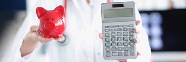 Doctor holding piggy bank and calculator