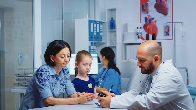 Medico che tiene la bottiglia di pillole e scrive istruzioni mentre parla con il genitore in clinica. medico, specialista in medicina che fornisce servizi di assistenza sanitaria consultazione trattamento diagnostico in ospedale