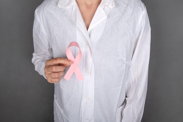 Doctor holding a pink ribbon symbol of the fight against breast cancer