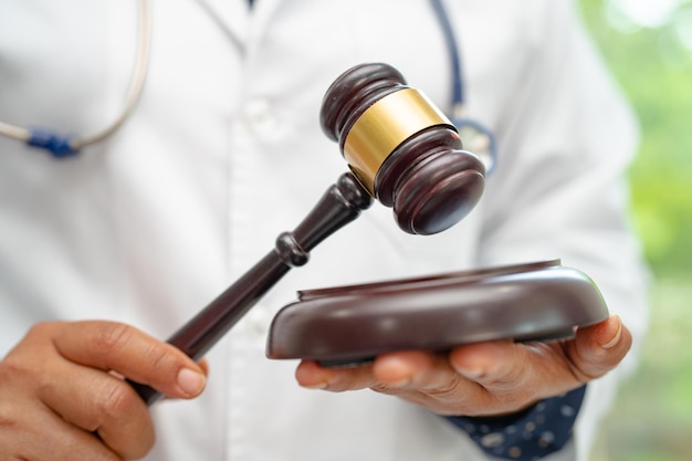 Doctor holding rechter hamer forensische geneeskunde medisch recht en misdaad rechtvaardigheid concept