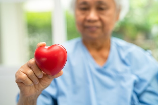 Doctor holding a red heart in hospital healthy strong medical concept