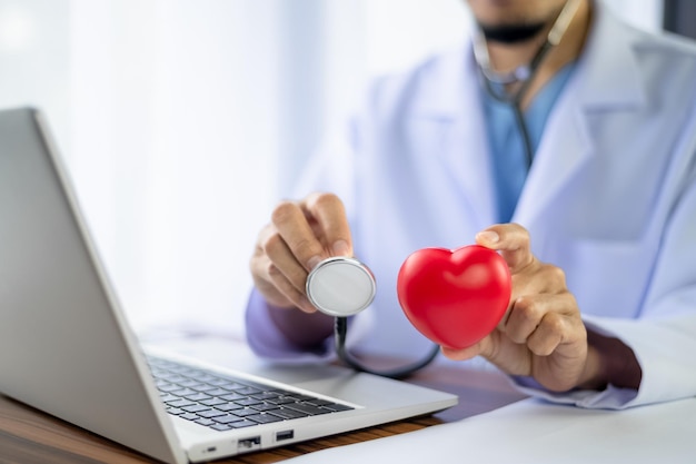 Doctor holding red heart in hospital office Medical health care and doctor staff service clinic concept