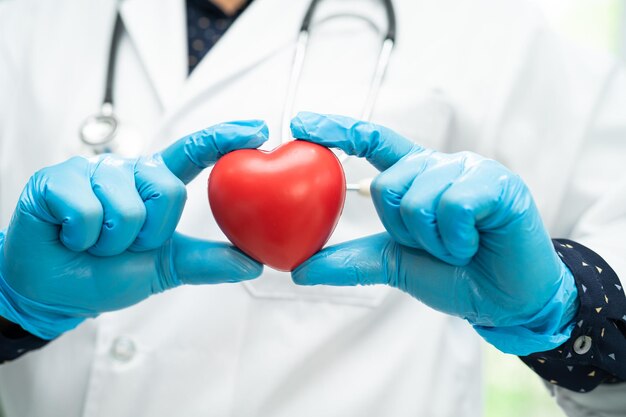 Doctor holding a red heart in hospital ward healthy strong medical concept