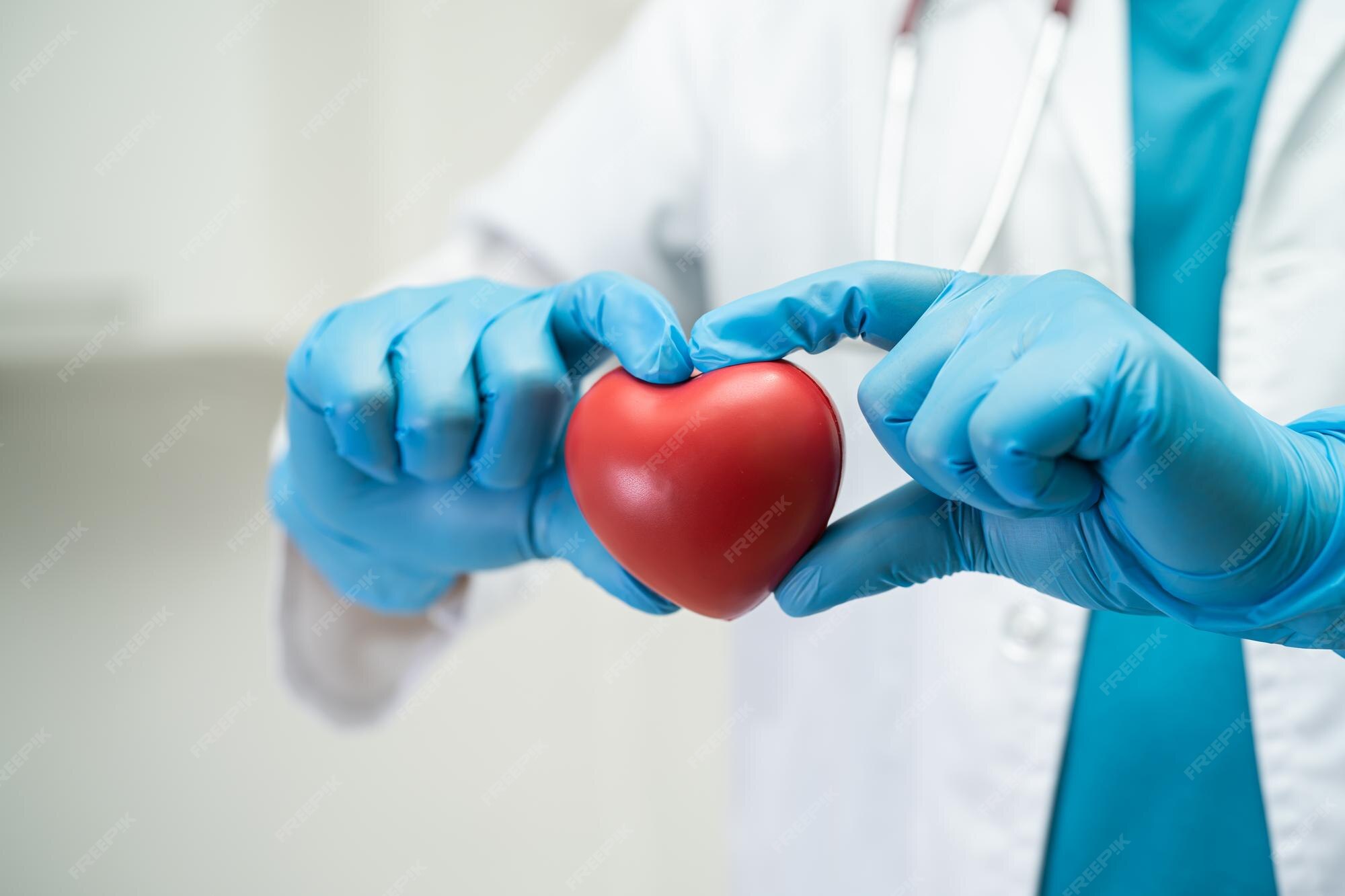 Premium Photo Doctor holding a red heart in hospital ward healthy Premium Photo Doctor holding a red heart in hospital ward healthy