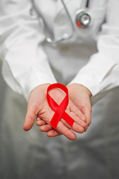 Doctor holding red ribbon. AIDS, HIV