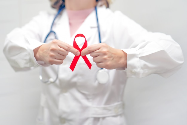 Doctor holding red ribbon. AIDS, HIV