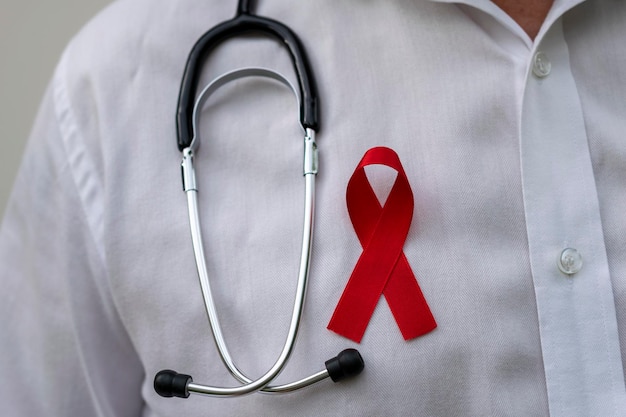 doctor holding red ribbon. AIDS prevention campaign. December red. blood donation