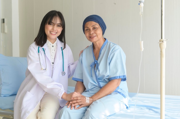 Medico che tiene la mano del malato di cancro anziano nell'assistenza sanitaria ospedaliera e nel concetto medicox9xa