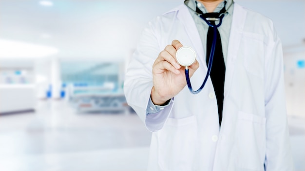 Doctor holding a stethoscope on background of Hospital ward