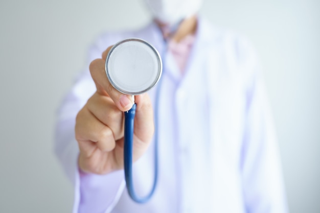 Doctor holding stethoscope on hands with wearing face mask