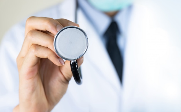 Doctor holding stethoscope at hospital