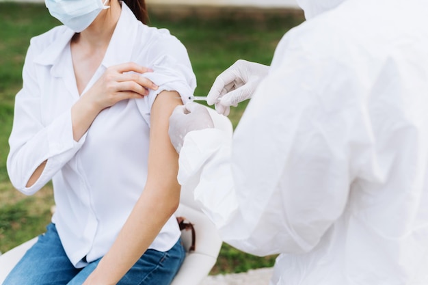 Doctor holding syringe  before make injection to patient in a medical mask. Covid-19 or coronavirus vaccine