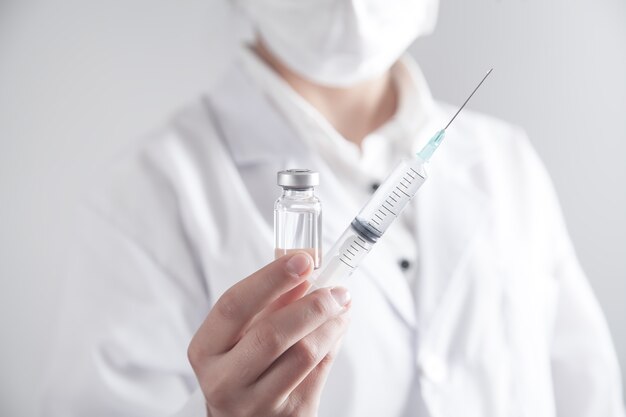 Doctor holding syringe and vaccine.