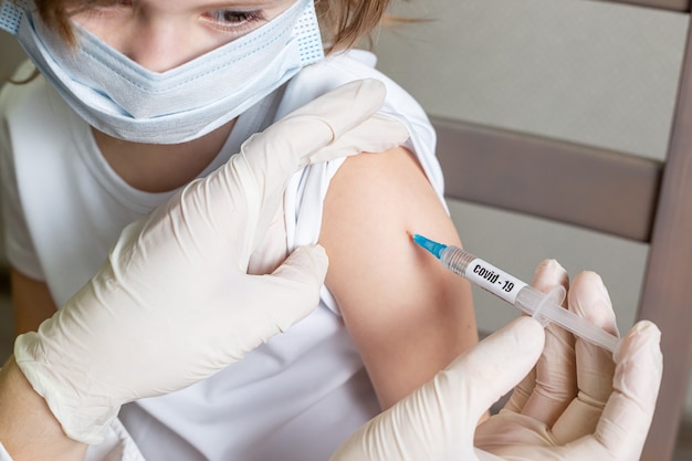 doctor holding syringe with covid-19 or coronavirus vaccine.