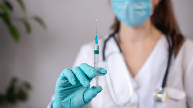 Doctor holding a syringe with a vaccine in her hands