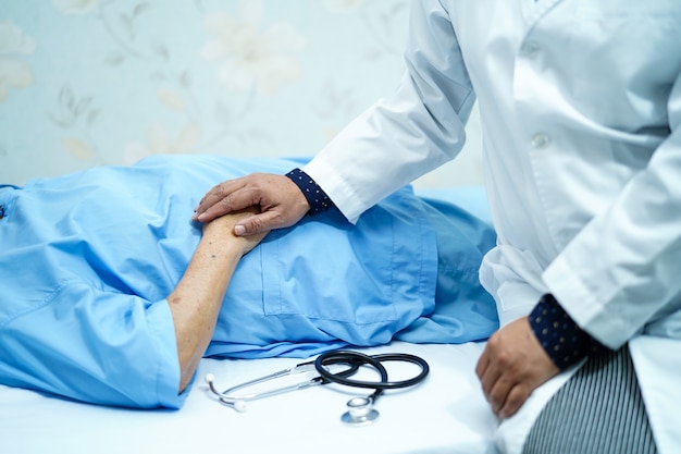 Doctor holding touching hands Asian senior or elderly old lady woman patient with love, care.  