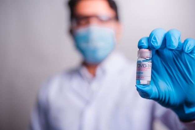 Doctor holding tube with Coronavirus vaccine and syringe. Healthcare And Medical concept.