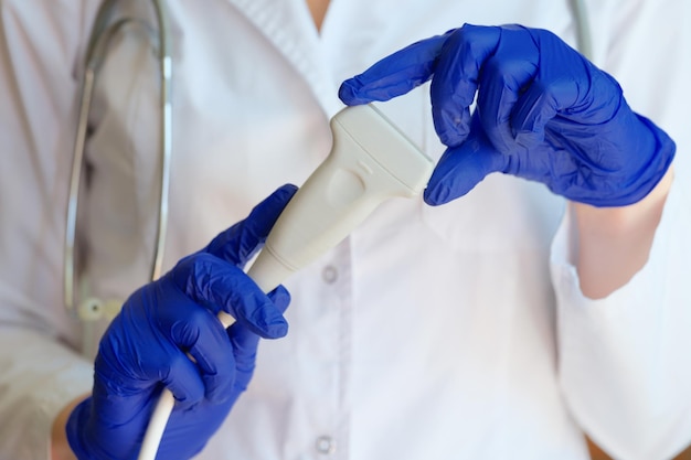 Doctor holding ultrasound scanner in clinic closeup medical checkup of internal organs concept