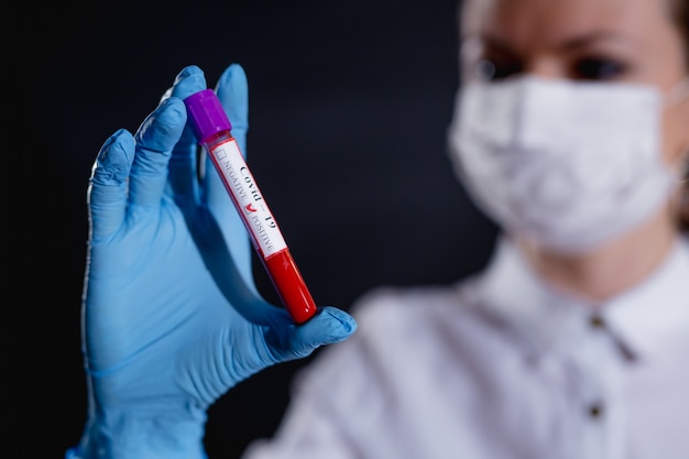 Doctor holding vial with blood