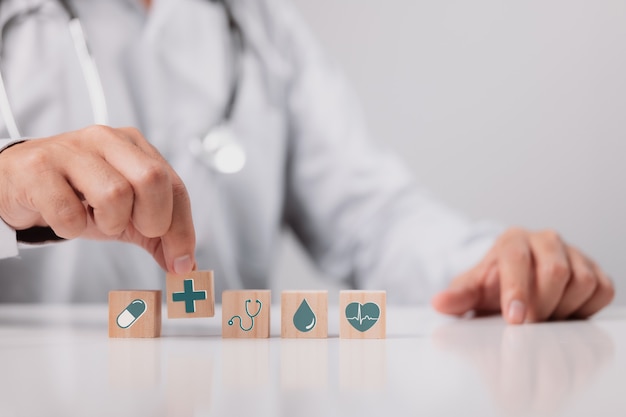doctor holding wood cube with medical icon, health insurance concept