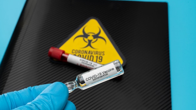 Doctor holds COVID 19 Coronavirus vaccine in his hand, infected blood sample in the sample tube, Vaccine and syringe injection It use for prevention, immunization and treatment from COVID-19