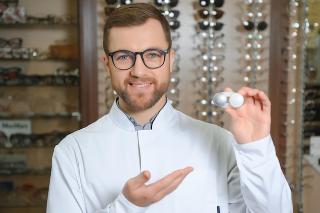 Doctor holds in his hand container with soft contact lenses for single use Ophthalmologist prescribes use of oneday contact lenses for vision correction Myopia and eyesight problem concept