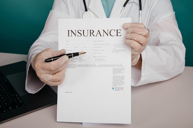 Photo doctor holds insurance contract in his office