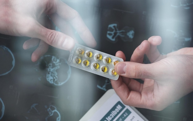 the doctor holds a pack of pills in his hand closeup