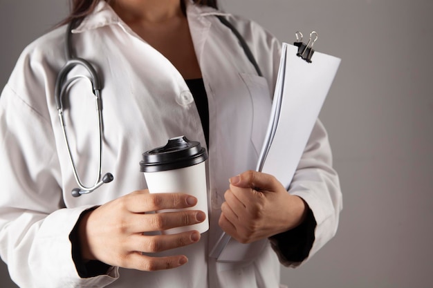Doctor holds a paper cup of coffee in hands