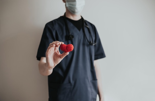 Photo the doctor holds the red heart in his hand the concept of health