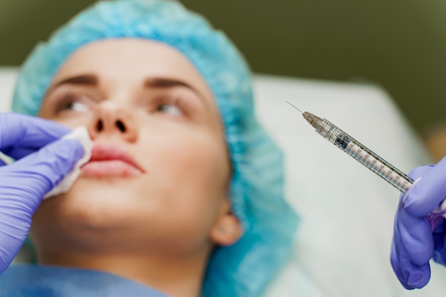 Doctor holds a syringe next to patient