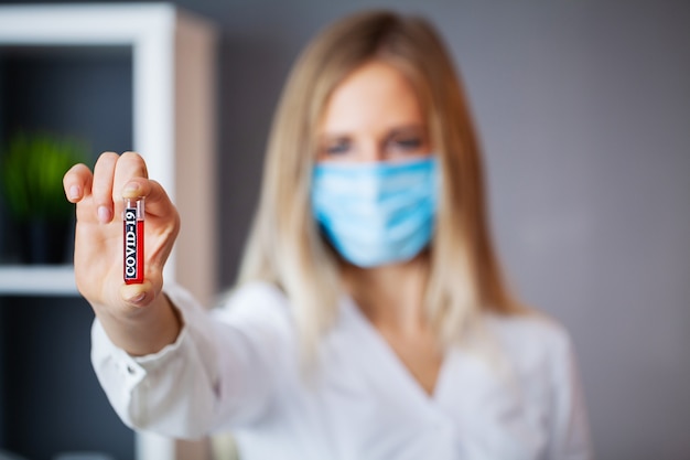 Doctor holds test tube with covid-19 test