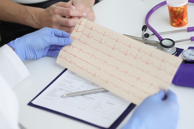 Doctor holds transcript of patient cardiogram in his hands