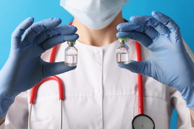 Doctor holds two medical ampoules with vaccine in his hands