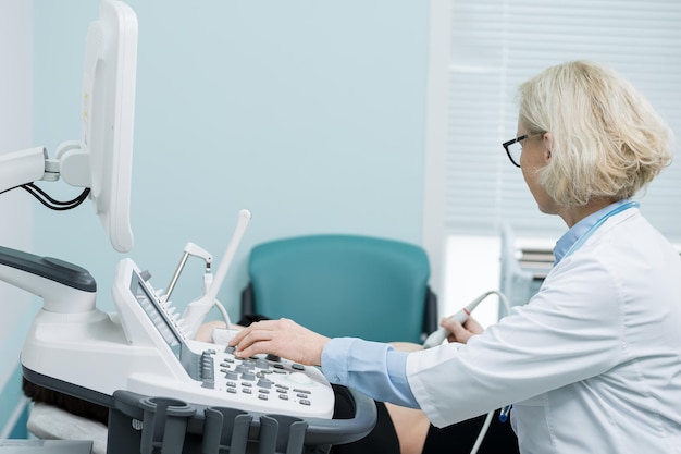 Photo doctor holds ultrasonic probe determining baby gender