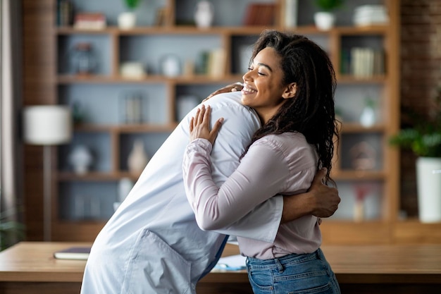 doctor hugging cheerful black lady patient clinic interior