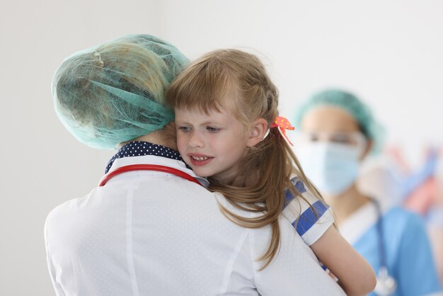 Foto medico che abbraccia piccola ragazza spaventata