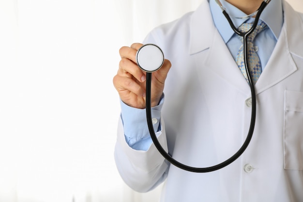Doctor in de medische jurk met zwarte stethoscoop, ruimte voor tekst