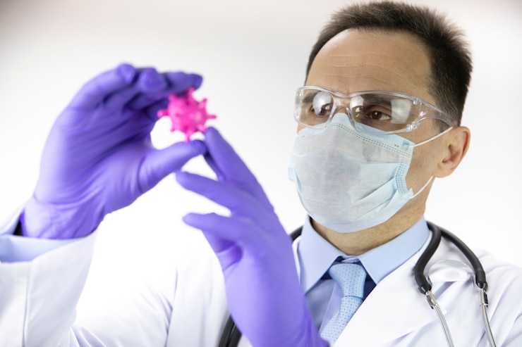 Doctor in de medische uniform, beschermend masker en bril kijken naar covid-19 cel