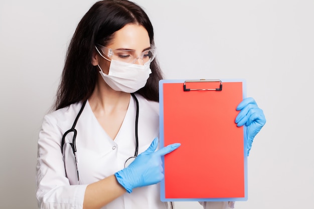 Doctor in een handschoenen, masker en bril heeft een blanco formulier met ruimte voor tekst