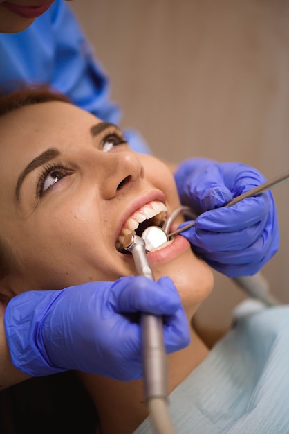 사진 치과에서 여성 환자의 이빨을 검사 제복을 입은 의사.